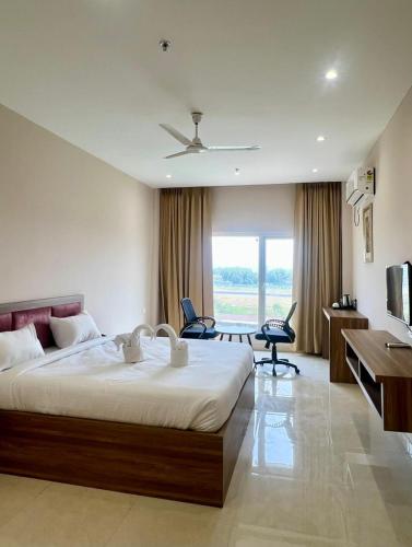 a bedroom with a large bed with a desk and chairs at Hotel Airport View in Pāsighāt