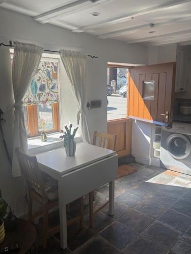 a kitchen with a white table and a window at The Old Stable in Abergavenny