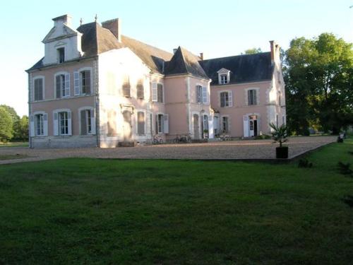 une grande maison blanche avec une grande pelouse dans l'établissement Château de Bois Renard, à Saint-Laurent-Nouan