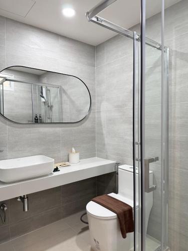 a bathroom with a toilet and a sink and a mirror at Ranana Bangkok in Bangkok