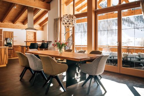 a dining room with a wooden table and chairs at Chasa Castello relax & spa in Samnaun