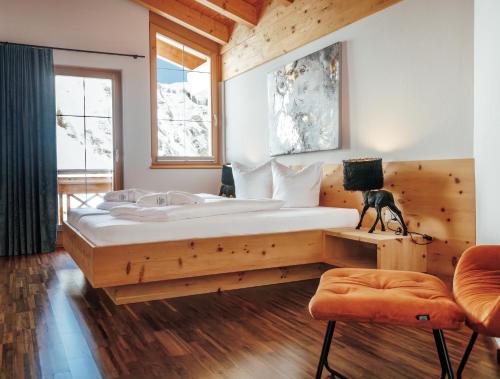 a bedroom with a large bed and a window at Chasa Castello relax & spa in Samnaun
