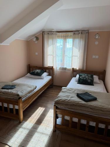 a bedroom with two beds and a window at Salaš Gnijezdo in Bačka Palanka