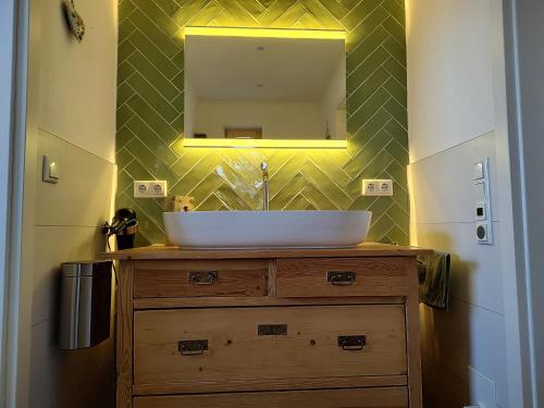 a bathroom with a sink and a mirror on the wall at Ferienwohnung Landliebe in Reichertsried