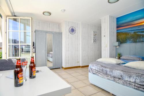 a bedroom with a bed and two bottles on a table at Bed en Bad De Koog in De Koog