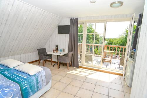 a bedroom with a bed and a table and a window at Bed en Bad De Koog in De Koog