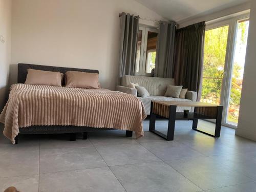 a bedroom with a bed and a couch and a table at U Mariki in Mikoszowa
