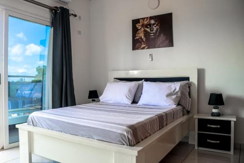 a bedroom with a large bed with a window at L'appartement Bleu d'Assinie in Assinie