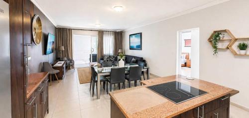 a kitchen and living room with a table and a dining room at Sunset Sails 2 Apartment in Langstrand