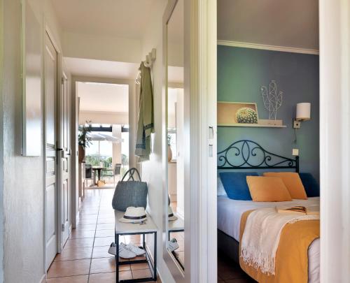 a bedroom with a bed with a blue accent wall at Résidence Pierre & Vacances Premium Les Calanques des Issambres in Les Issambres