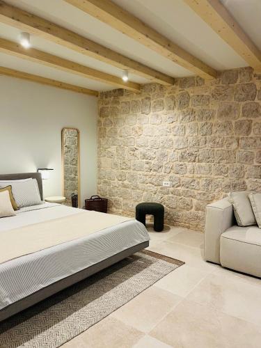 ein Schlafzimmer mit einem Bett und einer Steinwand in der Unterkunft Casa Maja in Vis