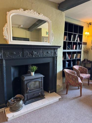 a fireplace with a mirror above it in a living room at Castle View Hotel in Chepstow