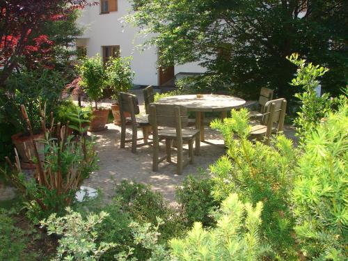 a patio with a table and chairs in a garden at Ferienwohnungen Knaller-Möd in Weissensee