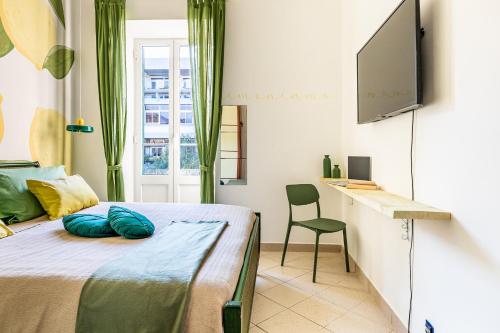 a bedroom with a bed and a desk and a television at Aromatico design 2 camere da letto / centralissimo in Diano Marina