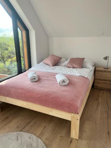 a bedroom with a large bed with a large window at Stodoły ForRest in Czarna