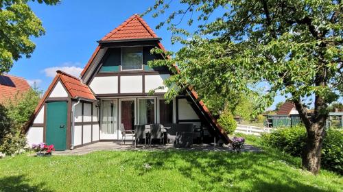a cottage with a gazebo on a lawn at Ferienhaus Ankerplatz Twielenfleth im Feriendorf Altes Land in Hollern-Twielenfleth