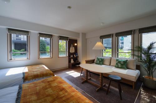 a bedroom with a bed and a couch and a table at The Apartment Hotel Shibuya 3 in Tokyo