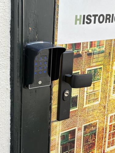 a black door handle with a sign on a building at Historic Centre Hotel in Amsterdam