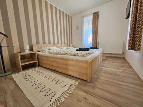 a bedroom with a bed and a window and a rug at Csenár Apartman Hegykő in Hegykő