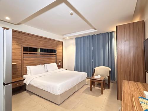 a hotel room with a bed and a chair at بيت لمار 3 للشقق المخدومه in Riyadh