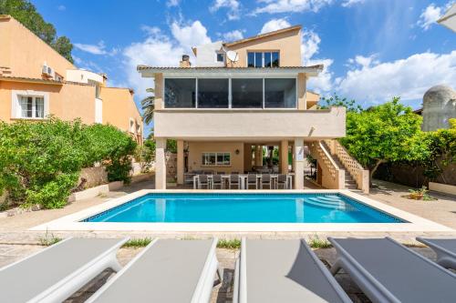 a villa with a swimming pool in front of a house at Villa Arenas in El Arenal