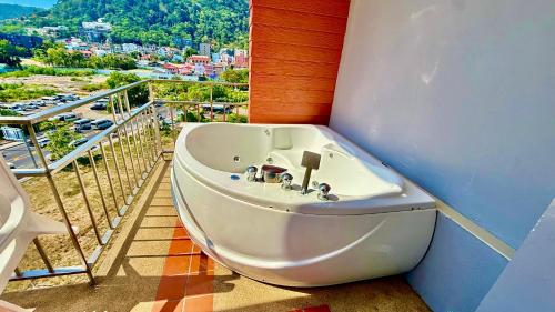 a bath tub sitting in a room with a balcony at APK Resort in Patong Beach
