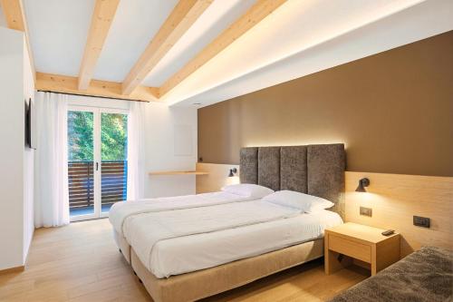 a bedroom with a large bed and a large window at Residence Diamant in Andalo