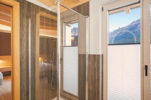 a glass shower door in a bathroom with a mountain view at Residence Diamant in Andalo