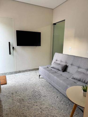 a living room with a couch and a flat screen tv at Casa nova e confortavel, Itabirito, MG in Itabirito