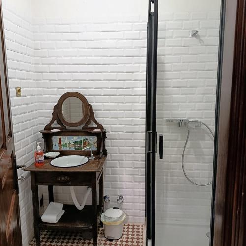 a white bathroom with a sink and a shower at Concha de Moledo in Moledo