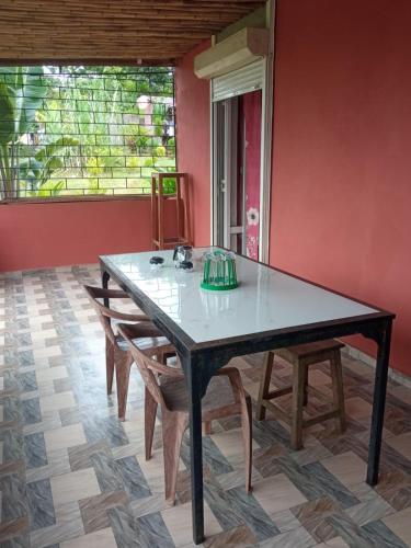 a table with chairs in a room with a window at Villa Marie in Nosy Be