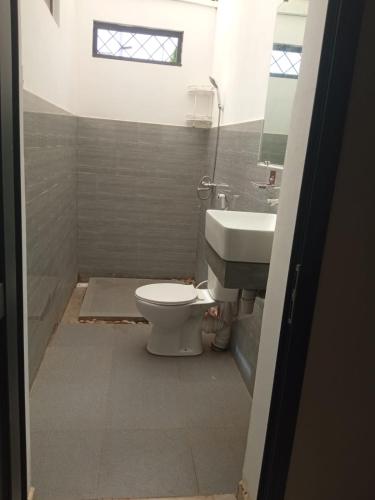 a bathroom with a toilet and a sink at Villa Marie in Nosy Be