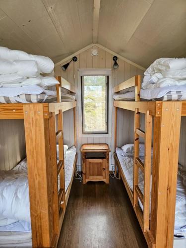 a bedroom with three bunk beds in a tiny house at Ekenäs Camping & Gästhamn in Ekenäs