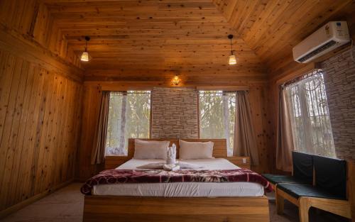 a bedroom with a bed in a wooden cabin at Resort Bihanga in Chālsa Mahābāri
