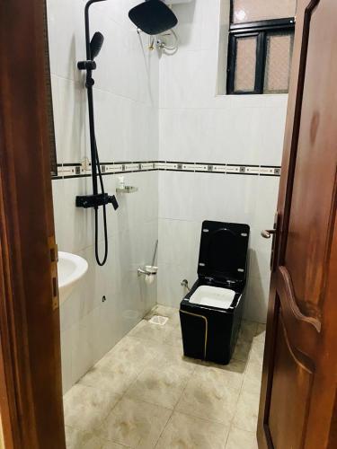 a bathroom with a toilet and a bath tub at KH KH Hotel in Kasese