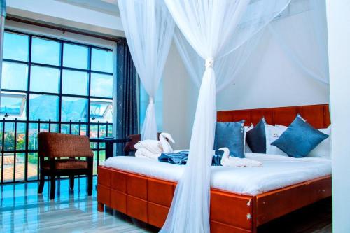 a bedroom with a bed with swans on it at KH KH Hotel in Kasese