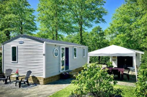 a small white caravan with a table and chairs at Camping de Pallegarste Eco Villa 141 in Mariënberg