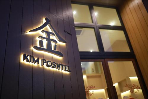 a sign on the side of a building at Kim Poshtel Hatyai in Hat Yai