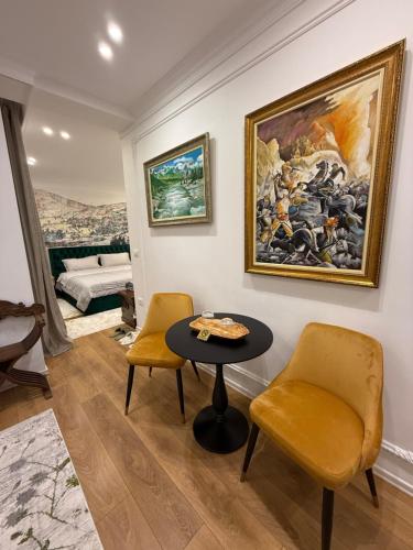 a living room with a table and two chairs at Mikpritja Korçë in Korçë