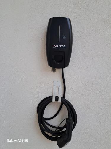 a black ac adapter hanging on a wall at Delfa Luxe Suite-Sustainable Luxury & EV Station in Supetar