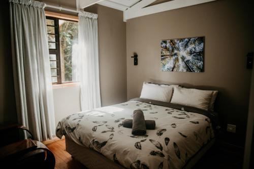 a bedroom with a bed with a stuffed animal on it at The Cabins Hogsback in Hogsback