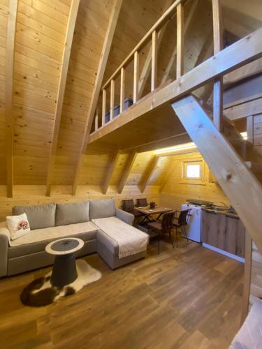 a living room with a couch and a staircase at Guest House Višnja in Žabljak