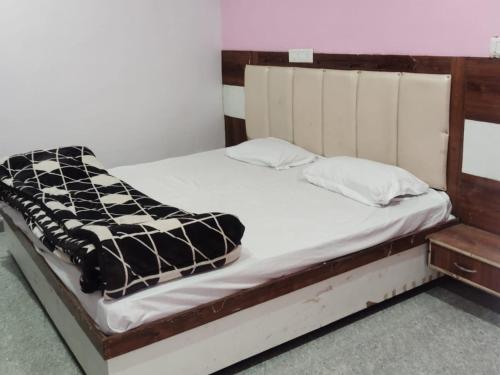 a bed with a black and white blanket on it at Royal Orbit By StayApart in Sonprayag