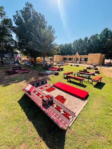 a group of picnic tables and benches in a field at Desert Safari in Margham