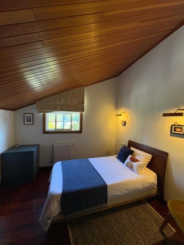 a bedroom with a large bed with a wooden ceiling at The Eira - Spacious duplex with lush garden in Nigrán