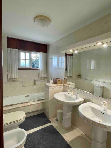 a large bathroom with two sinks and a tub at The Eira - Spacious duplex with lush garden in Nigrán