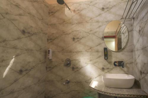 a bathroom with a sink and a mirror at Aureva Kamla Heritage in Jaipur