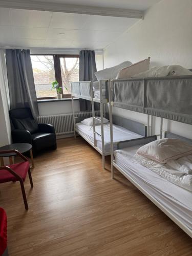 a room with three bunk beds and a chair at Sjømannskirken Narvik in Narvik
