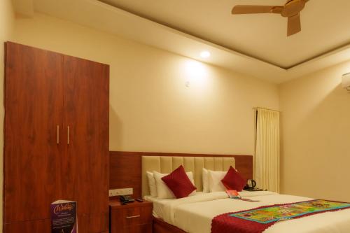 a bedroom with two beds and a wooden cabinet at Aureva Kamla Heritage in Jaipur