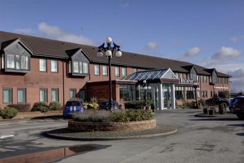a building with a street light in a parking lot at Best Western Plus Milford Hotel in South Milford